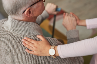 A caregiver offering support to an elderly man, illustrating the compassionate approach to continuing care in Milton, WI.