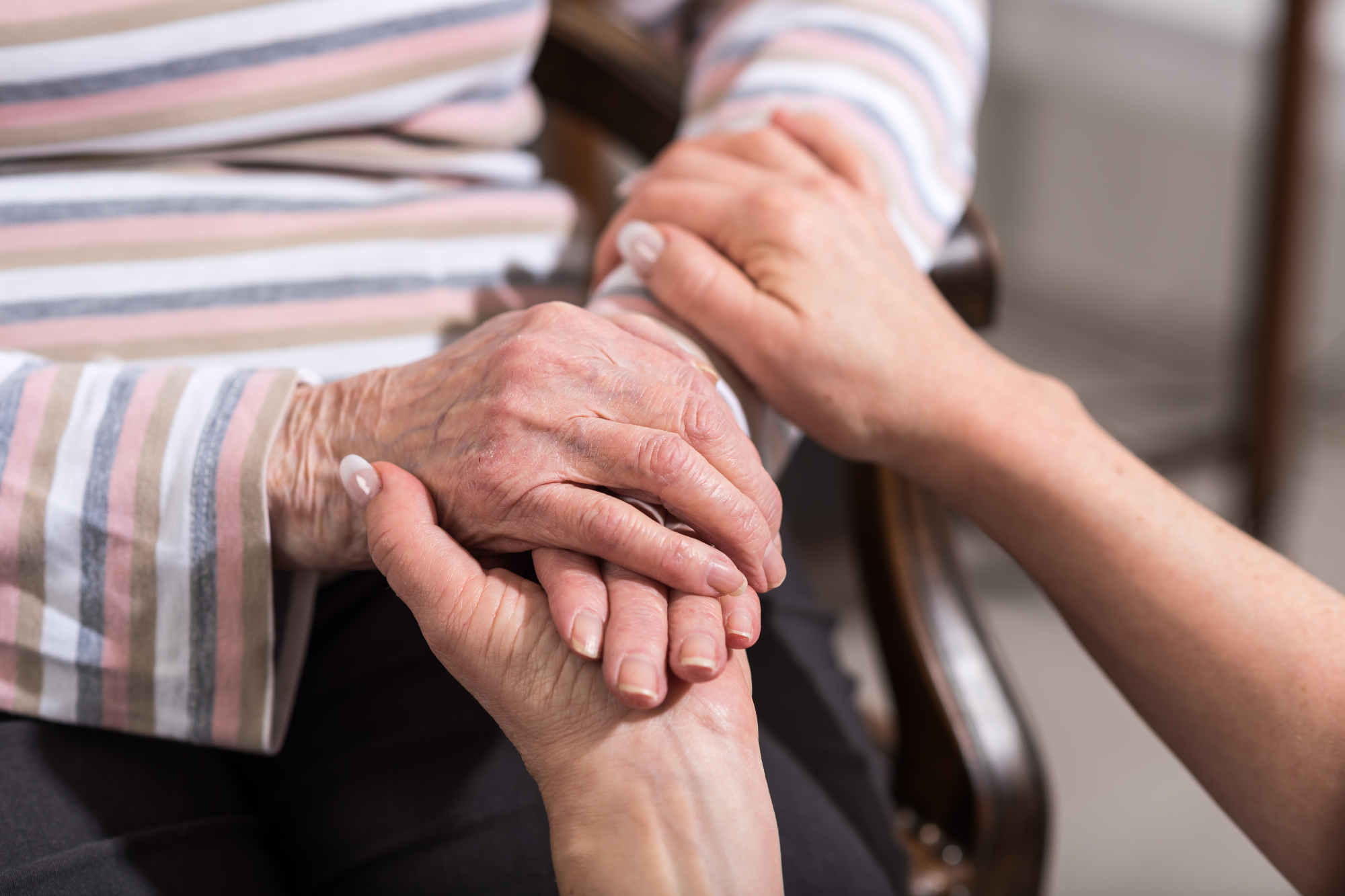 Hands of a senior held by a caregiver, emphasizing assisted living programs in Beloit, Wisconsin.